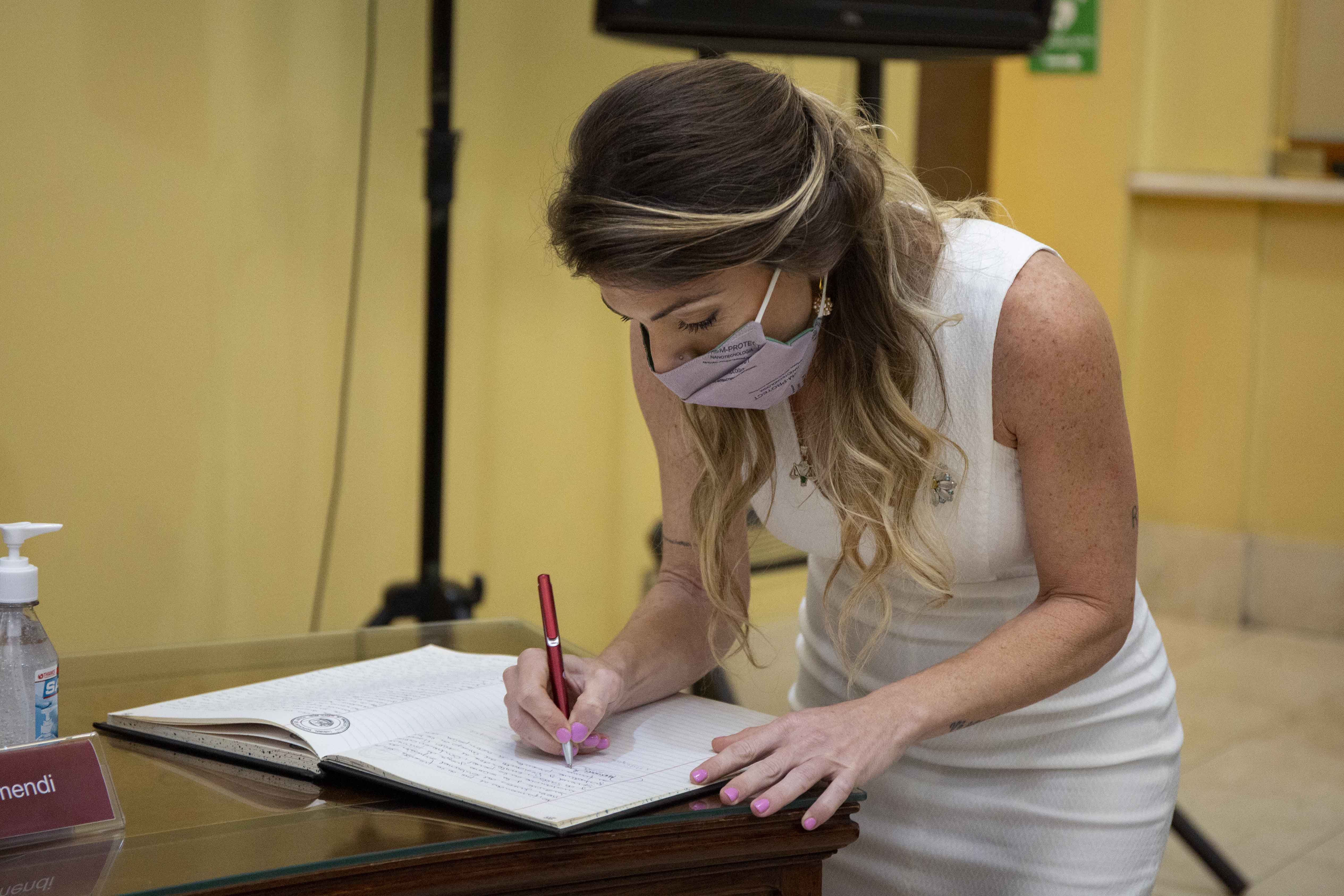 La doctora Karina Giselle Andrade firma el libro de actas.